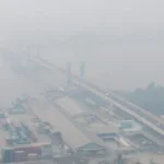 Kabut asap tebal menyelimuti kawasan permukiman dan jembatan di Palembang pada pagi hari