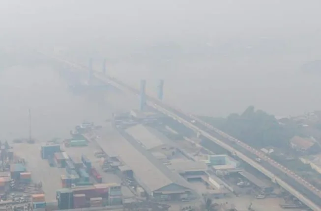 Kabut asap tebal menyelimuti kawasan permukiman dan jembatan di Palembang pada pagi hari