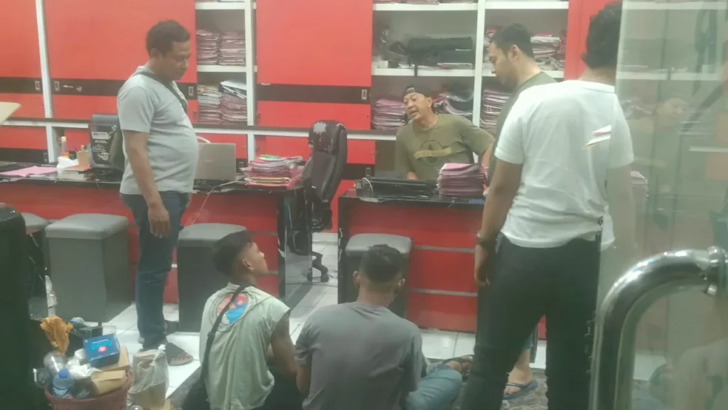 Ilustrasi deretan toko emas di jalan pertokoan Jember pada pagi hari dengan garis polisi di depan pintu