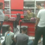 Ilustrasi deretan toko emas di jalan pertokoan Jember pada pagi hari dengan garis polisi di depan pintu