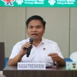 Ilustrasi gedung kepolisian daerah dengan palu sidang dan berkas perkara di meja