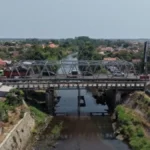 Ilustrasi ruas jalan tol yang ditutup dengan rambu pengalihan arus dan truk berbelok ke jalur alternatif